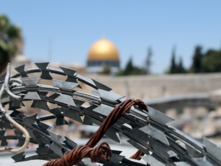 An image of barbed wire in Jerusalem. What does it mean to be an apartheid state?