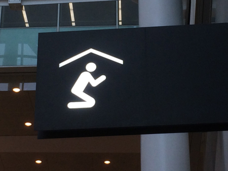 Icon symbolizing someone kneeling in prayer used a an airport multi-faith center.